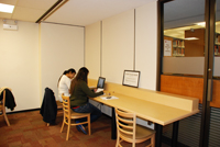 Students sitting at a long wooden table in the new space.