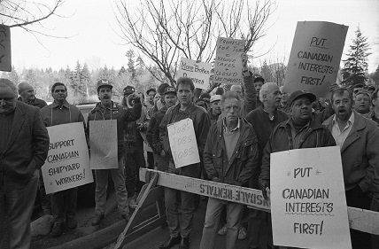 Shipyard workers gather with protest signs