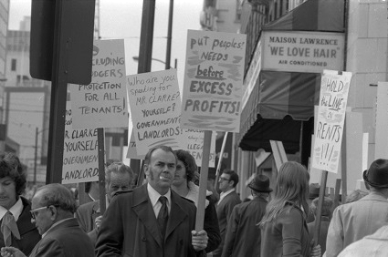 Tenants walk with protest signs outside Rentalsman's office