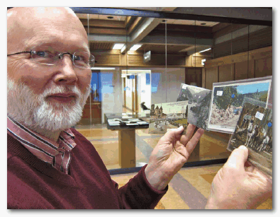 Librarian Eric Swanick holds postcards