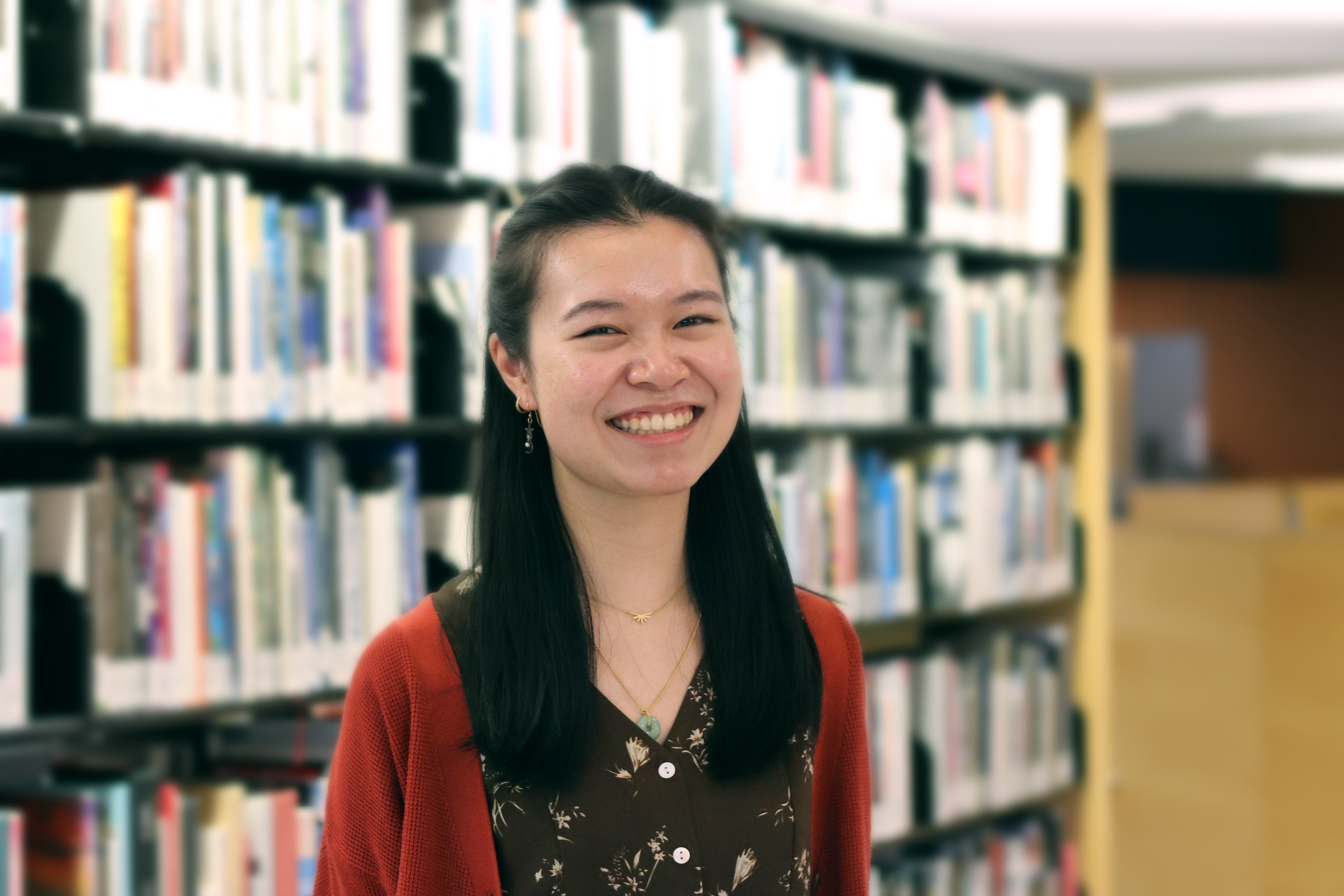 Melissa smiling in front of library bookshelves