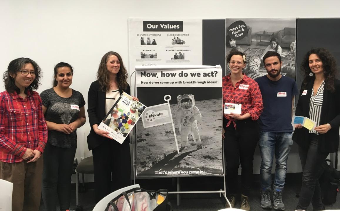 A group of people stand by a poster