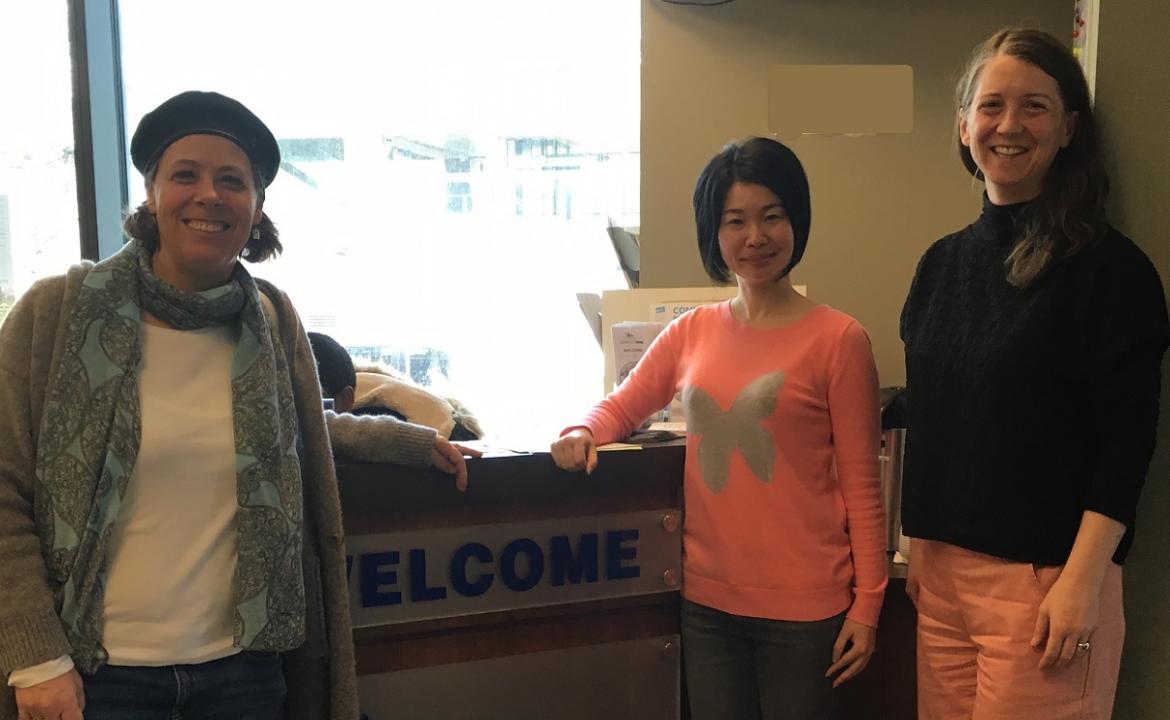 Three people smile at the camera