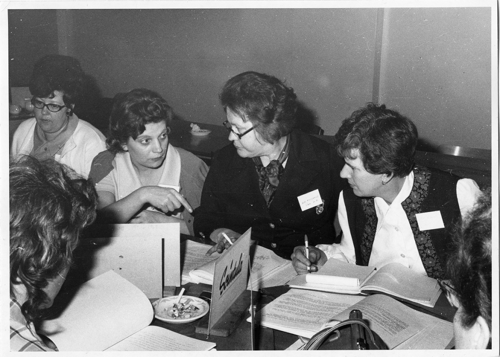 Group of UFAWU members speaking to each other arounda table and writing notes