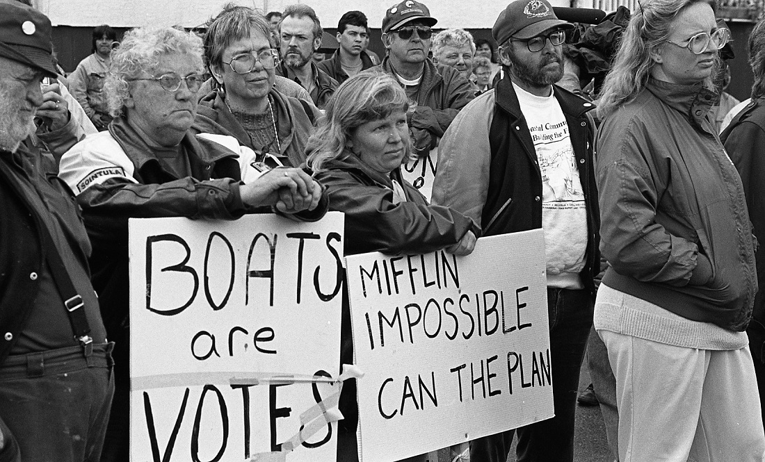 Group of protestors holding 2 signs. One states: "Boats are Votes". The other states: "Mifflin Impossible / Can the Plan"