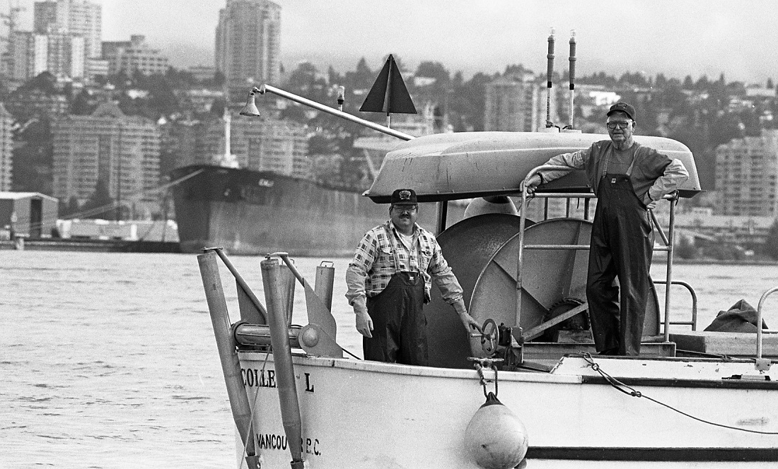 Two fishers standing on a fishing vessel