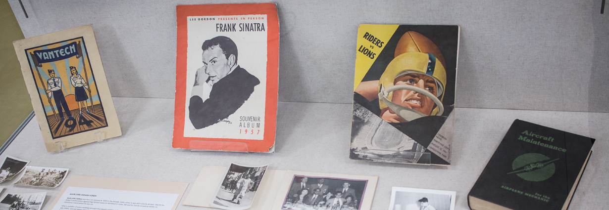 A yearbook, "Van Tech 1941," a Frank Sinatra "Souvenir Album, 1957," a "Riders vs Lions" football program, and an aircraft maintenance manual.