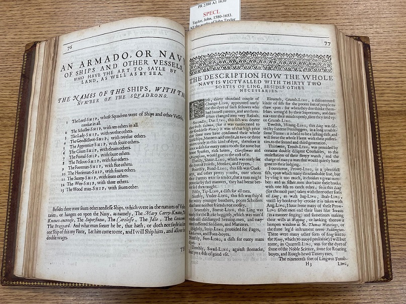 Open book displaying various book elements like headpiece, initials, catchwords and signature