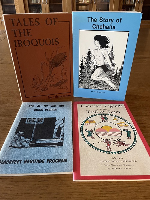four books on the table including stories of Iroquois, Sto:lo, and Cherokee