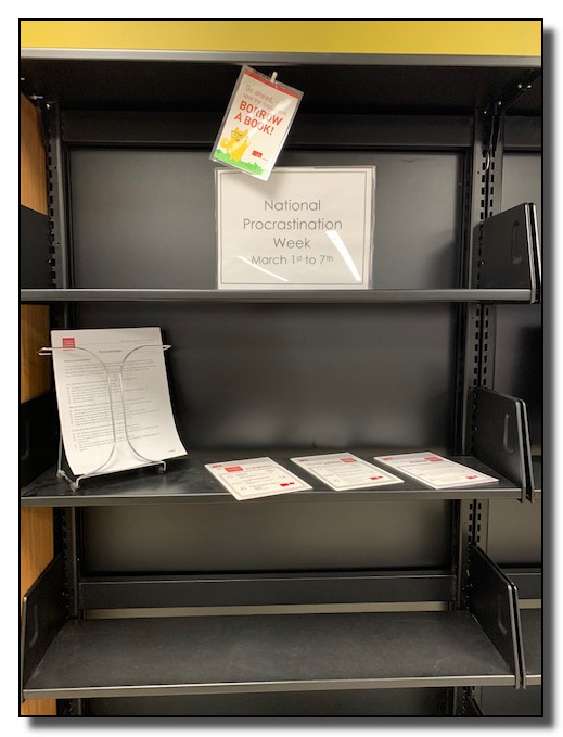 Picture of empty bookshelves with a sign on the top shelf: "National Procrastination Week: March 1st to 7th"