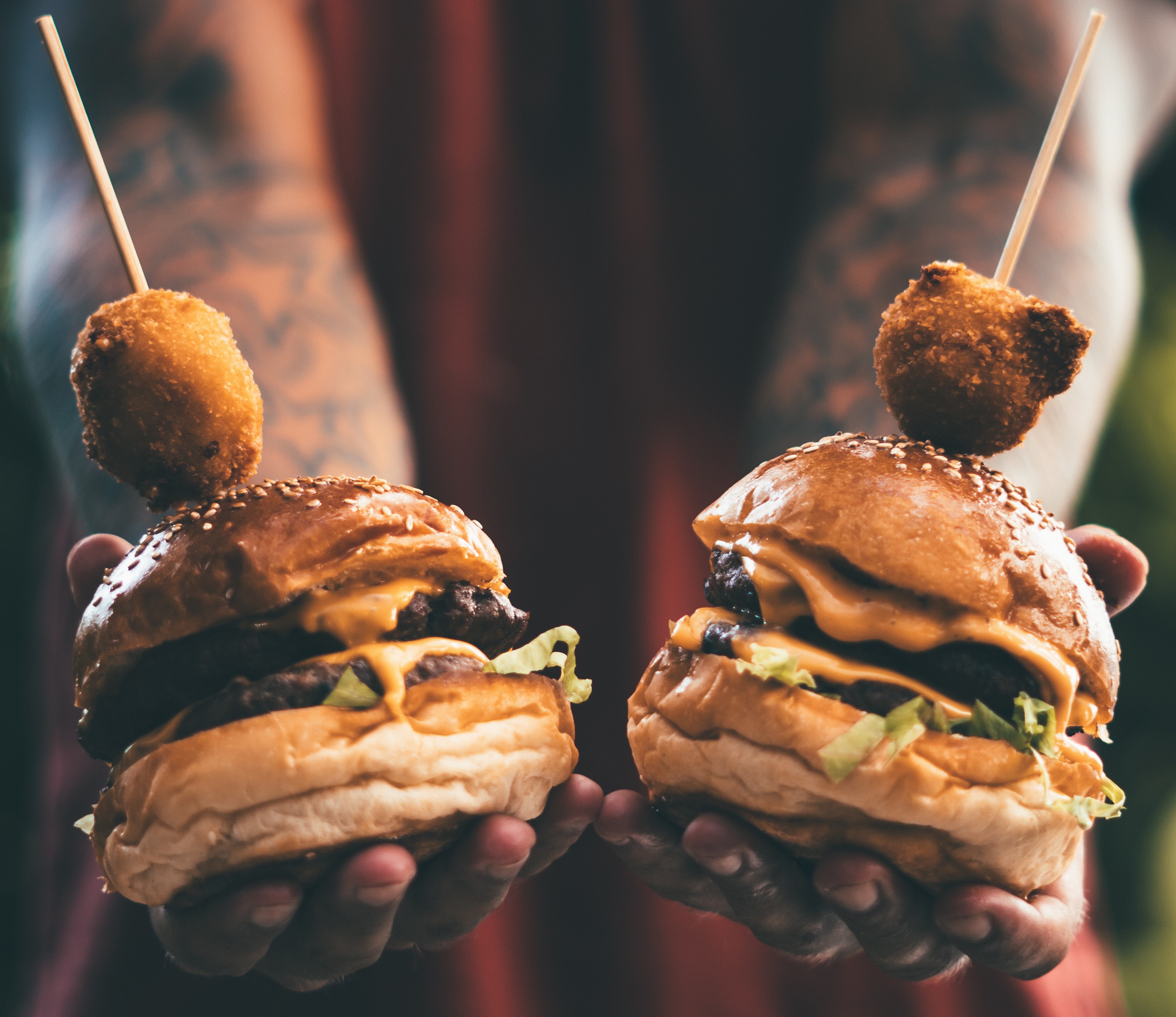 image of someone holding two cheeseburgers