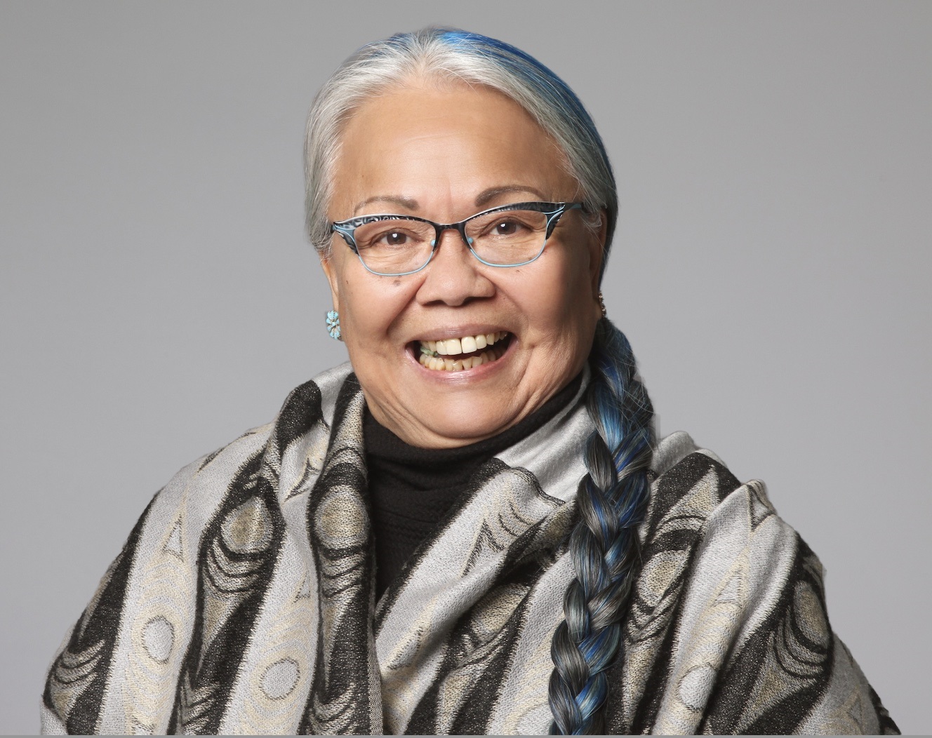 Dorothy Christian: a woman smiling, wearing glasses and a shawl, with her hair in a long braid.