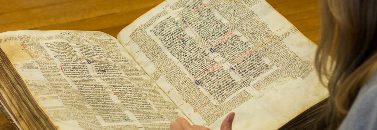 Researcher touching a page of a medieval manuscript from 1269