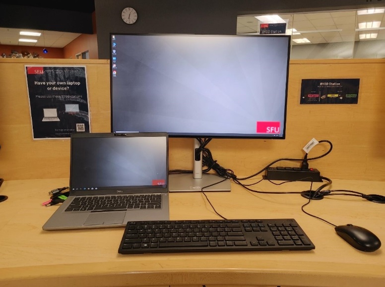 A large monitor attached to a laptop, keyboard, and mouse