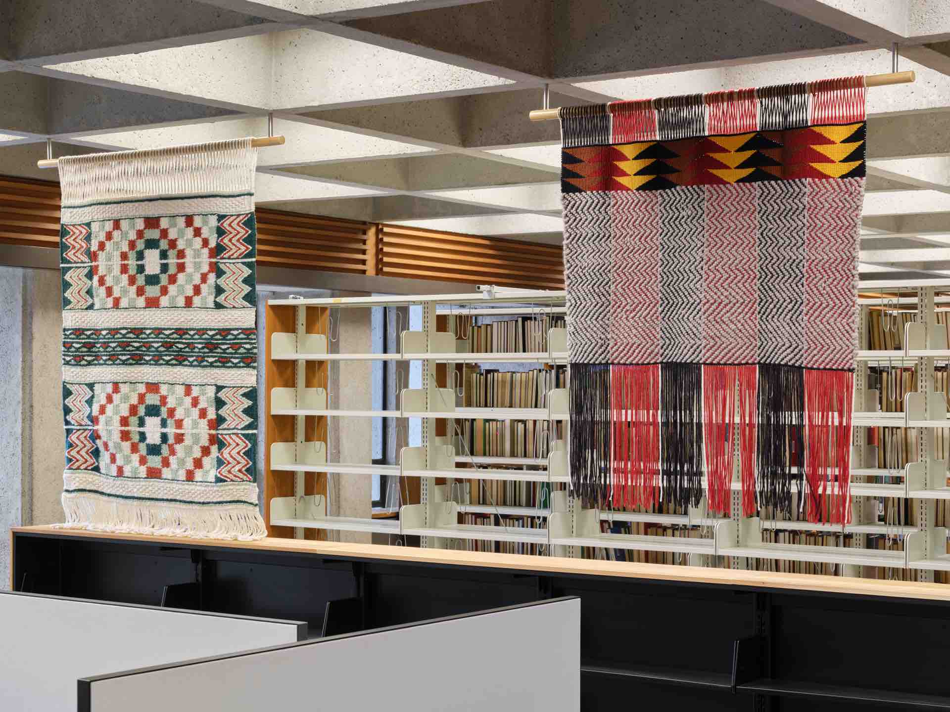 Weavings done by Atheana Picha and Chief Janice George and Buddy Joseph hanging above bookcases.