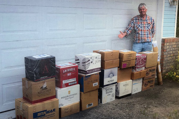 Image of the donor, Rick McGrath standing next to 23 boxes filled with his donated Ballard collection